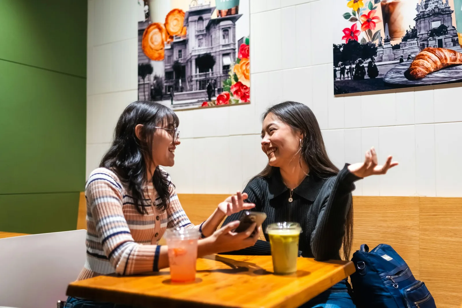 Two people talking across a cafe table